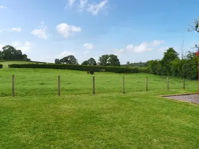 a fence in a field with a horse in the distance at Tilly - Uk49798 in Brecon