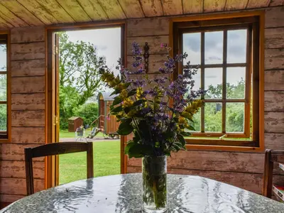 a vase of flowers on a table in a cabin at Sweet Briar - Uk49797 in Brecon