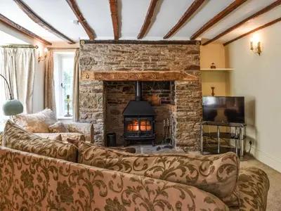 a living room with a couch and a fireplace at Priory Cottage in Clifford