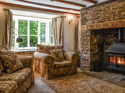 a living room with a couch and a fireplace at Priory Cottage in Clifford