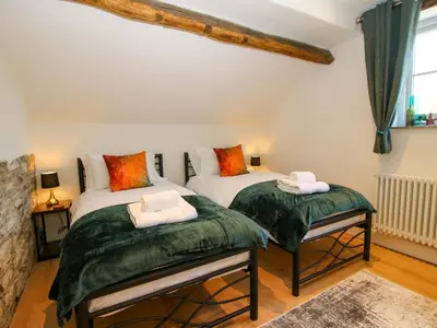 two twin beds in a room with green covers at 10 Bridge Street in Craven Arms