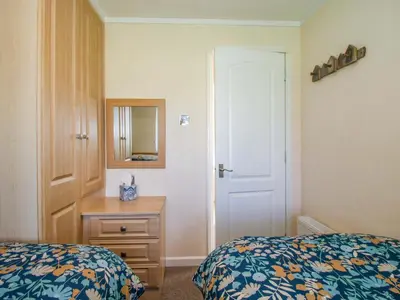a bedroom with two beds and a dresser and a mirror at Dunromin in Montgomery