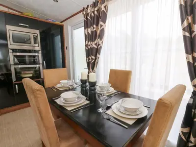 a dining room with a black table and chairs at Ty Seren in New Quay