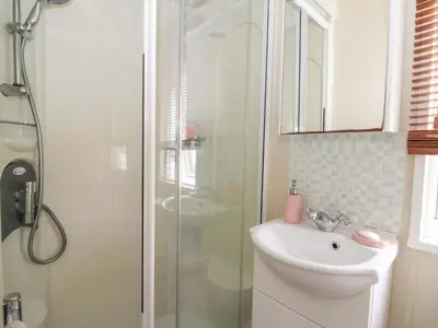 a bathroom with a toilet and a sink and a shower at Ty Seren in New Quay