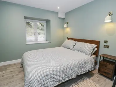 a bedroom with a bed and a window at Frongoch Old Power House in Dolgellau