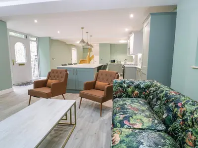 a living room with a couch and a table and a kitchen at Frongoch Old Power House in Dolgellau