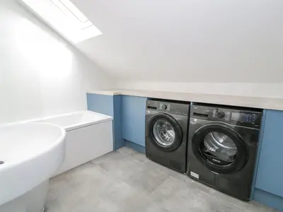 a laundry room with a washing machine and a sink at Frongoch Old Power House in Dolgellau