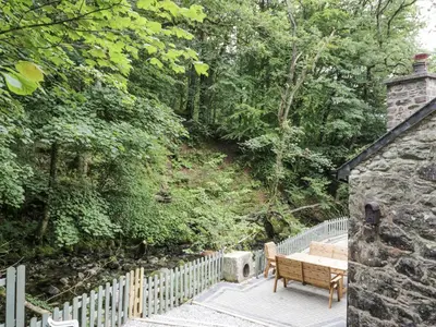 a wooden bench sitting next to a fence at Frongoch Old Power House in Dolgellau