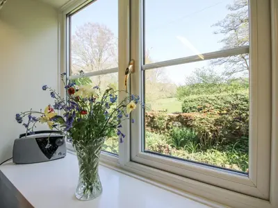 a vase of flowers sitting on a window sill at Caradoc Cottage in Church Stretton