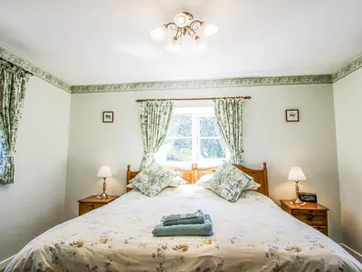 a bedroom with a bed and a window at Caradoc Cottage in Church Stretton