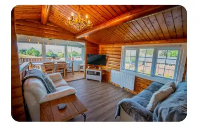a living room with two couches and a dining room at Snowdonia Escapes# Scenic Log Cabin with Views, WIFI & 2 Double bedrooms in Trawsfynydd