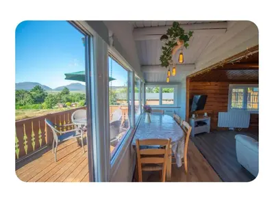 a room with a balcony with a table and chairs at Snowdonia Escapes# Scenic Log Cabin with Views, WIFI & 2 Double bedrooms in Trawsfynydd