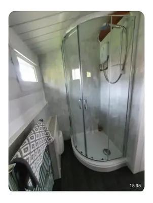 a bathroom with a shower with a glass door at Snowdonia Escapes# Scenic Log Cabin with Views, WIFI & 2 Double bedrooms in Trawsfynydd