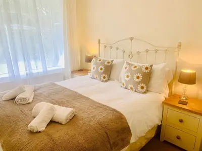 a bedroom with a bed with two towels on it at Riverside Bungalow in Llanbedr