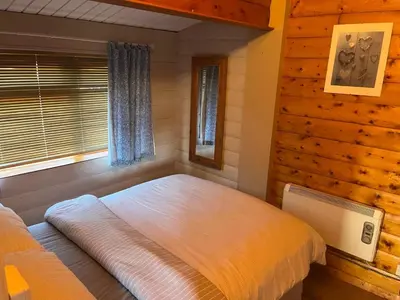 a bedroom with a large bed in a log cabin at Home From Home LogCabin in Trawsfynydd