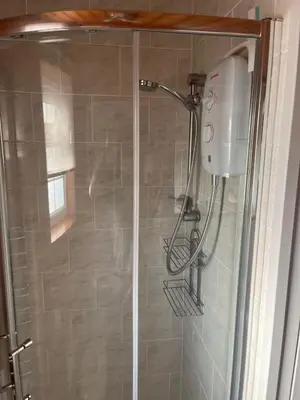 a shower with a shower head in a bathroom at Home From Home LogCabin in Trawsfynydd