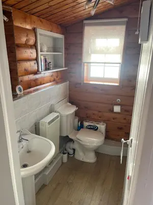 a bathroom with a white toilet and a sink at Home From Home LogCabin in Trawsfynydd