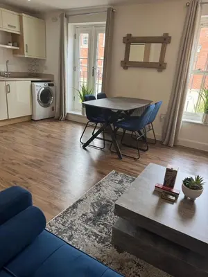 a living room with a table and chairs and a kitchen at Town centre abode with gated parking in Shrewsbury