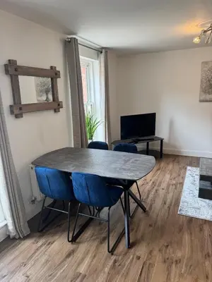 a dining room with a table and blue chairs at Town centre abode with gated parking in Shrewsbury