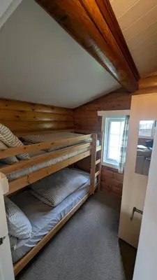 a room with three bunk beds in a cabin at Happy Place LogCabin in Trawsfynydd
