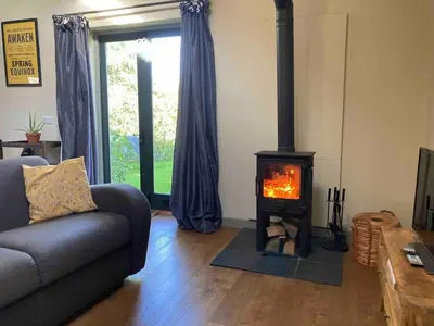 a living room with a fireplace and a couch at Little Hare Lodge - Near Ludlow in Lane to Richards Castle