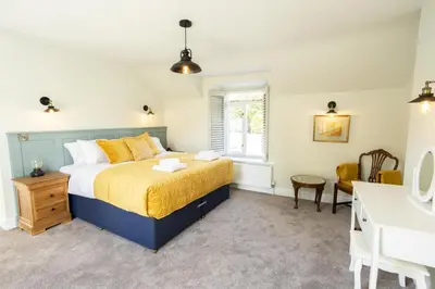 a bedroom with a king sized bed and a sink at Hen Llwyn by Birch Stays New Home in Llangadwaladr