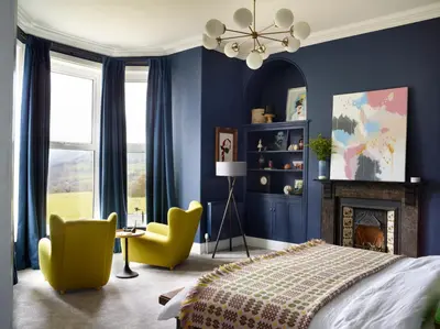a bedroom with blue walls and a bed and a chair at The Royston in Llanbrynmair