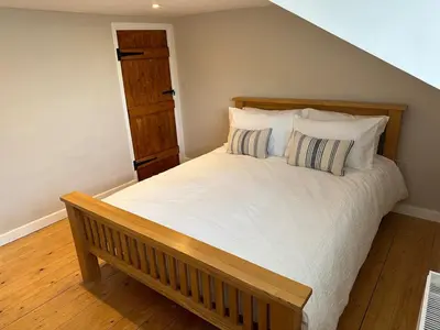 a bedroom with a large bed with pillows at Bear cottage in Brecon