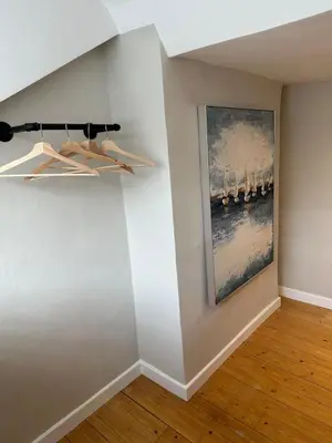 a room with a painting on a wall with hangers at Bear cottage in Brecon