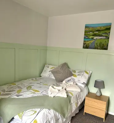 a bedroom with a bed with a picture on the wall at The Old Ford inn in Llanhamlach