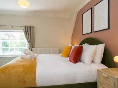 a bedroom with a white bed with colorful pillows at The Loft - a stylish 2-bed in prime central location - Pass the Keys in Shrewsbury