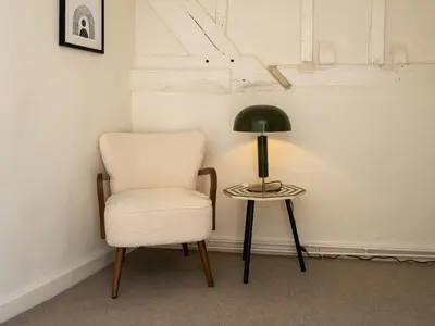 a chair and a lamp next to a side table at The Loft - a stylish 2-bed in prime central location - Pass the Keys in Shrewsbury