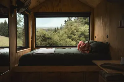 a bed in a room with a large window at Hydra in Llangollen