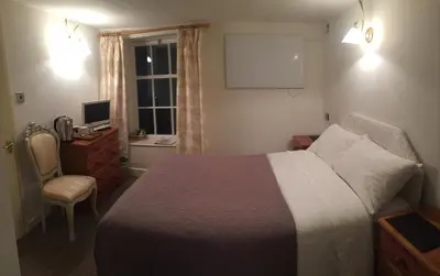 a bedroom with a bed and a desk and a window at Borderers Inn in Brecon