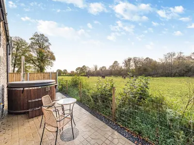 a patio with a table and chairs and a field at Coach House - Uk49793 in Cribyn