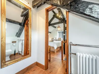 a bathroom with a mirror and a bedroom at Coach House - Uk49793 in Cribyn
