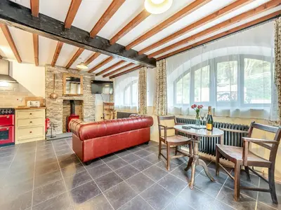 a living room with a red leather couch and a table at Coach House - Uk49793 in Cribyn