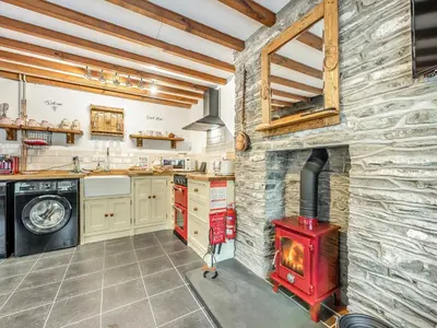 a kitchen with a brick wall and a red stove at Coach House - Uk49793 in Cribyn
