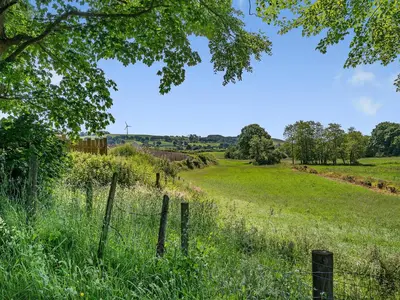 a field of grass with a fence in the foreground at Sheep Shed - Uk49794 in Cribyn