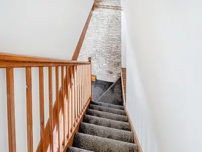 a staircase in a house with a stone wall at Sheep Shed - Uk49794 in Cribyn