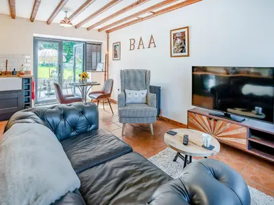 a living room with a couch and a flat screen tv at Sheep Shed - Uk49794 in Cribyn
