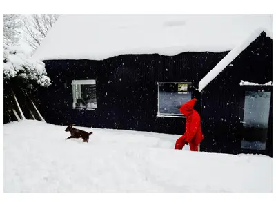 a person in red walking a dog in the snow at Croft Lodge Studio in Leominster
