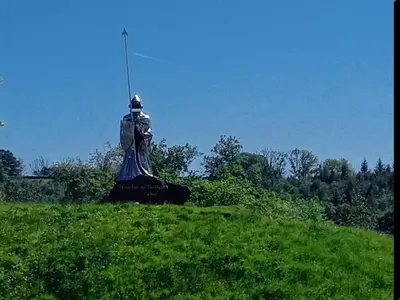 a statue of a man sitting on top of a field at Chandler Ranch Llandovery Cynghordy in Cynghordy