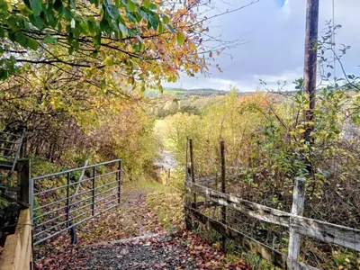 a gate on a trail with a fence at Cosy Rural Gilbert Hights Llandovery Cynghordy in Cynghordy