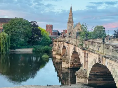 an old bridge over a river in a city at English Bridge Court in Shrewsbury