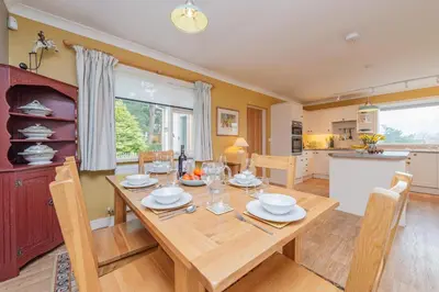 a kitchen and dining room with a wooden table and chairs at Pear Tree Cottage in Shrewsbury