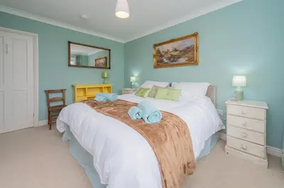 a bedroom with a large bed with towels on it at Pear Tree Cottage in Shrewsbury