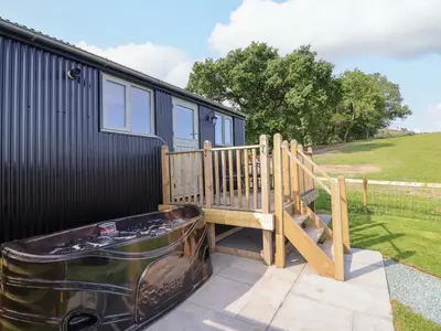 a deck with a tub next to a tiny house at Cheviot in Oswestry