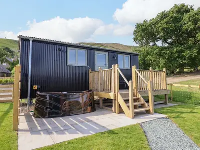 a tiny house with a deck and a staircase at Cheviot in Oswestry