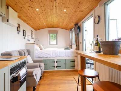 a small kitchen with a bed in a tiny house at Cheviot in Oswestry